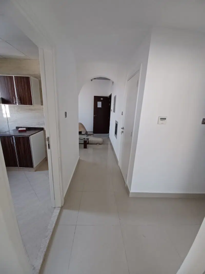 Apartment with two bedrooms, a hallway, two bathrooms, and a balcony for rent in Al Nuaimiya 2 in Ajman.